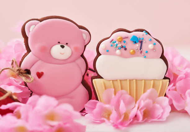 Valentine day cookies in pastel colors. Gingerbread bear cookies with flowers. Birthday, Womens Day or Valentine's Day greeting card template. Gingerbread on pink background. Sweet gift.
