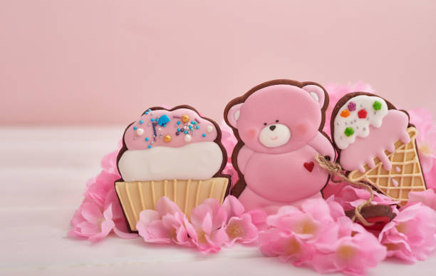 Valentine day cookies in pastel colors. Gingerbread bear cookies with flowers. Birthday, Womens Day or Valentine's Day greeting card template. Gingerbread on pink background. Sweet gift.