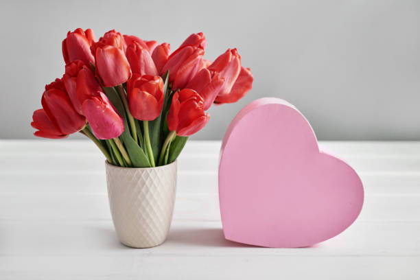 istock Red tulip flower and gift box isolated on white background. 2198135793