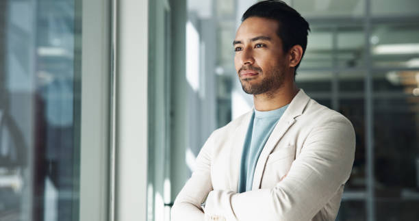 istock Office, thinking or Asian man with ideas, arms crossed and future plan for creative problem solving. Window, serious or proud business advisor daydreaming of profit growth, inspiration or opportunity 2198137866