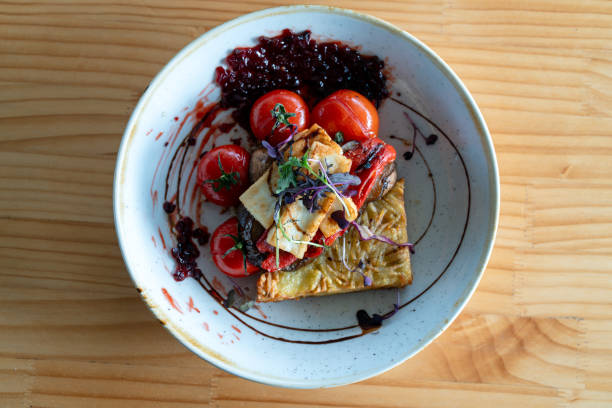 A deliciously plated breakfast featuring grilled halloumi cheese, roasted tomatoes, sautéed mushrooms, hash browns, and a tangy berry compote. A visually stunning dish for food photography and culinary inspiration