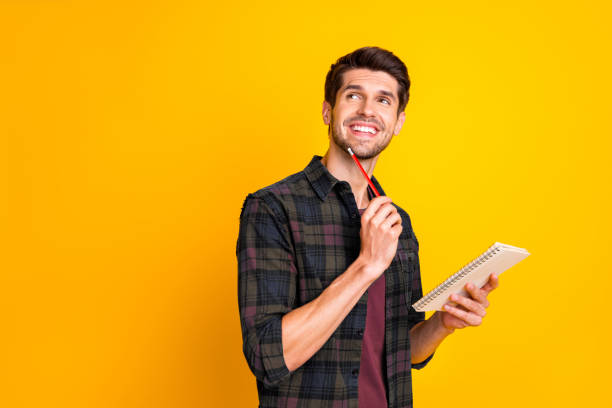 istock Photo of nice guy with organizer in hands making notes creating startup idea wear casual checkered shirt isolated yellow color background 2198138574