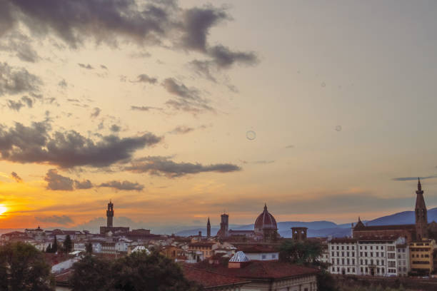 Firenze in warm golden hour light. Sunset over the city with dramatic clouds. Sunset over Florence. The sky painted in vibrant colors of orange and blue. Romantic sunset in Italy. Travel blog. Ads