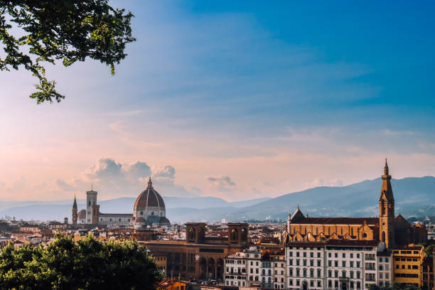 Firenze in warm golden hour light. Sunset over the city with dramatic clouds. Sunset over Florence. The sky painted in vibrant colors of orange and blue. Romantic sunset in Italy. Travel blog. Ads web