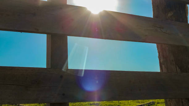sun between the corral boards with blue sky in the background