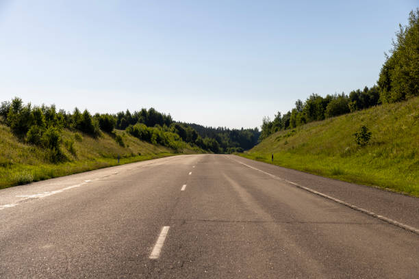 istock an empty straight paved road against a blue sky background 2198147695