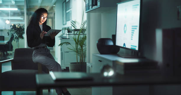 istock Business woman, night and tablet with statistics for analytics, corporate data or analysis at office. Female person, accountant or analyst working late on technology for company performance or trends 2198148900