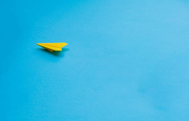 istock Yellow paper airplane on blue background 2198160051