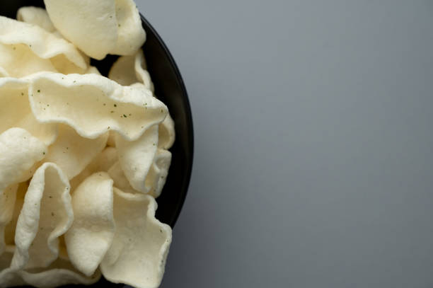 istock Crispy White Chips in Black Bowl on Gray Background 2198160766