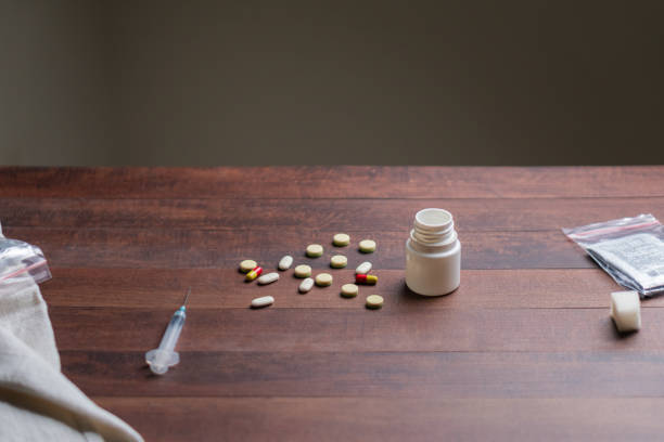 istock Scattered Pills and Syringe on Wooden Table 2198162203