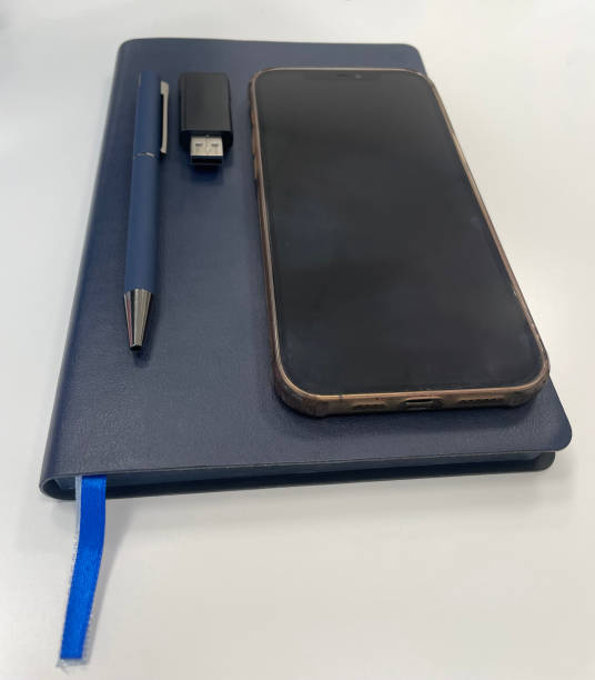 istock A blue notebook, a pen, a USB flash card, and a smartphone are placed on a clean white surface 2198162286