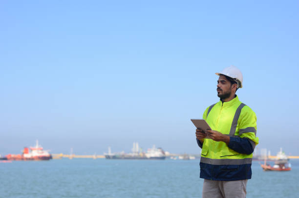 istock Front view of engineer standing holding tool back and communicating with the team via walkie-talkie 2198163001
