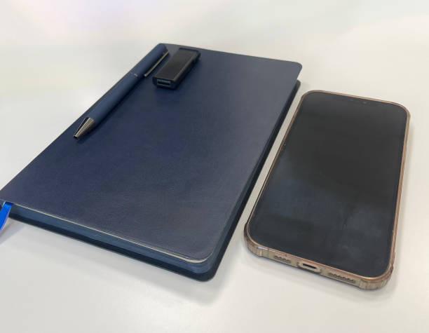 istock A blue notebook, a pen, a USB flash card, and a smartphone are placed on a clean white surface 2198163682