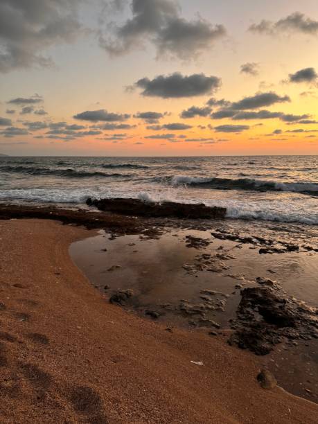 istock Sunset on the seashore with waves and clouds 2198169646