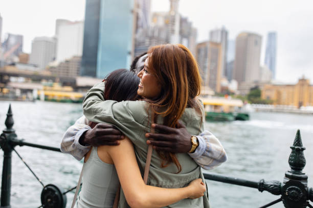 istock Group of Young Friends Hugging by the Waterfront in Downtown 2198169844