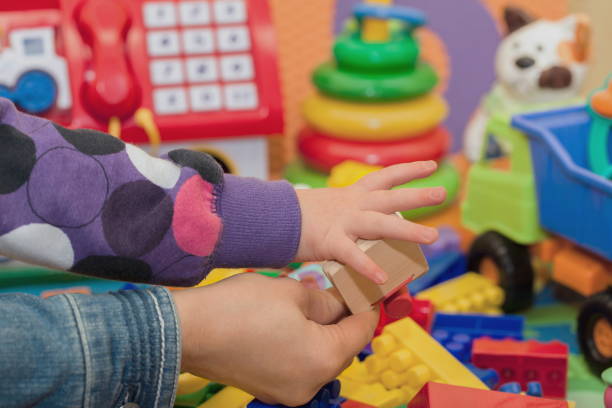 istock Mother's hand holds her daughter while she plays 2198176790