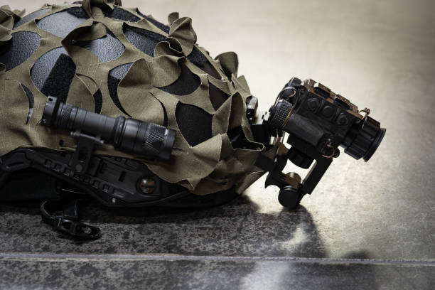 istock A tactical helmet with a thermal imaging monocular and a flashlight lies on a concrete floor. 2198178800