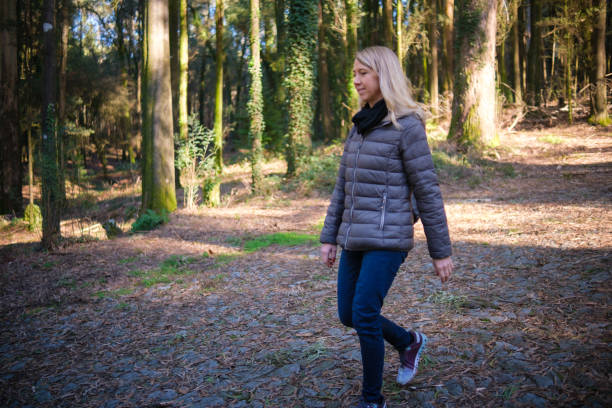 istock Woman walking in the forest 2198184511