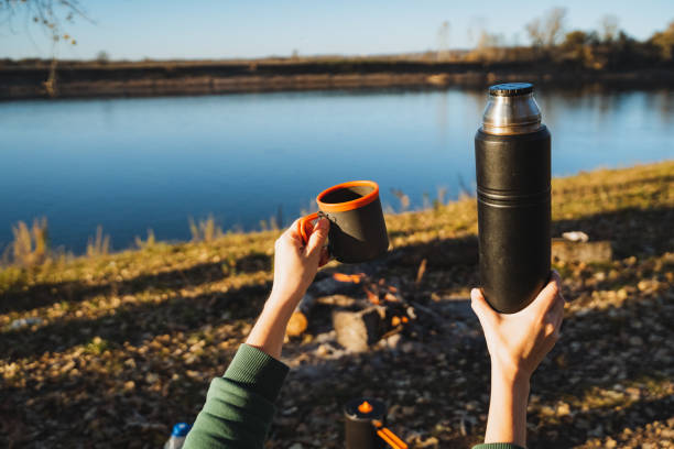 istock Taking pleasure in a warm and delicious beverage while sitting by the beautiful river a memorable outdoor adventure moment to cherish 2198184532