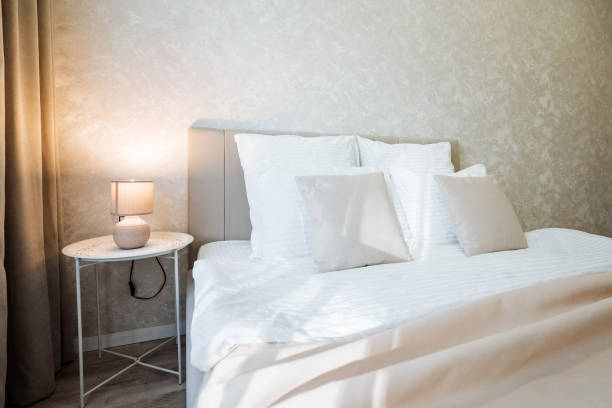 istock The inviting bedroom features a comfortable bed, charming nightstand, stylish lamp, and crisp white sheets, creating a warm atmosphere perfect for relaxation and a good nights sleep 2198185197