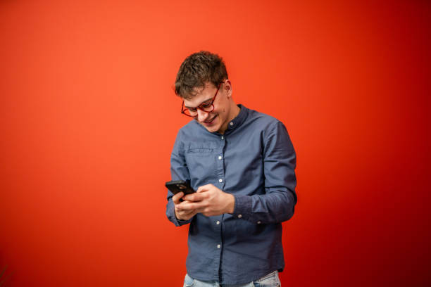 istock young man use mobile phone stand in front red background studio shot 2198189177