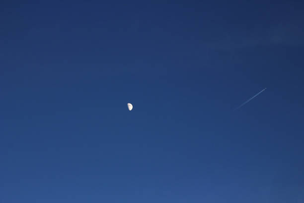 A half moon and a flying plane in the corner