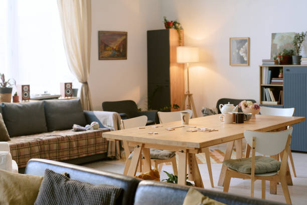 Wide shot of fully equipped living room with comfortable furniture, wooden table with bingo game on top in center of room, copy space