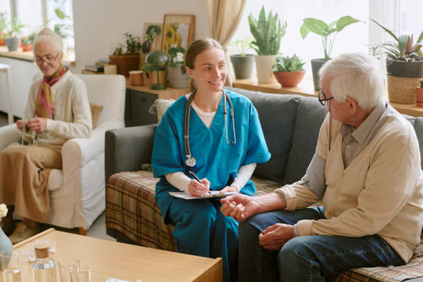 istock Woman Writing Prescription for Elderly Man 2198198366