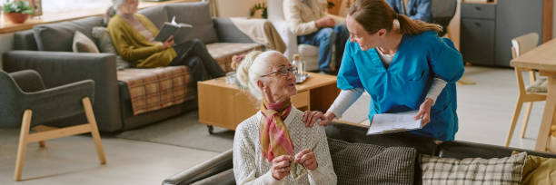 istock Header with Nurse Checking Senior Woman on Sofa 2198199716