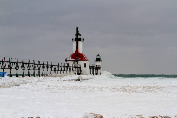 St Joseph Pier Lighthouse on banks of Lake Michigan on snowy winter day.