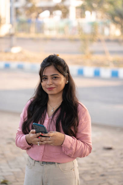 istock Smiling woman typing on mobile phone in a park 2198203873