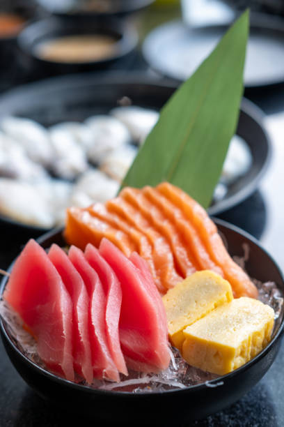 Sashimi set, Salmon, Tuna and Tamago with vegetable and ice in a bowl, served in a restaurant