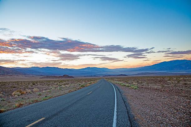 istock Scenic desert road at sunset with colorful clouds and mountain backdrop 2198204451