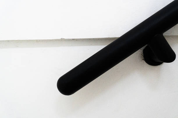 A black handrail mounted on a white wall, creating a modern and minimalist architectural detail.