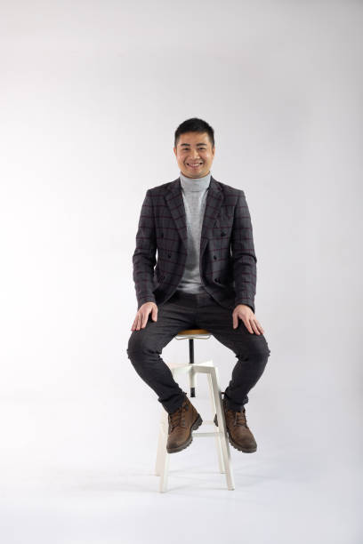 istock Stylish Male Model Posing on a Wooden Stool 2198205714