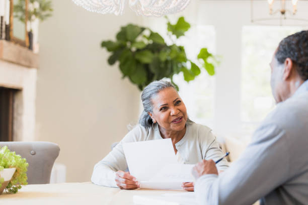 istock Mature Couple Reviewing Documents Together at Home 2198206041