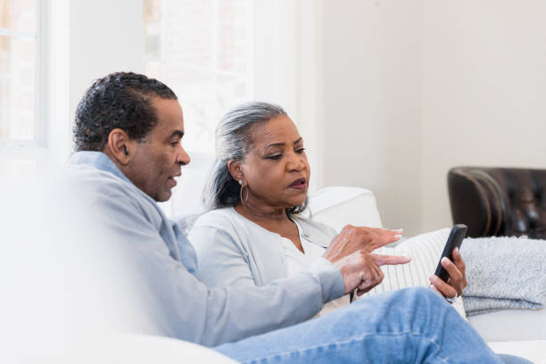 istock Senior Couple Using Smart Phone Together on Couch 2198206067