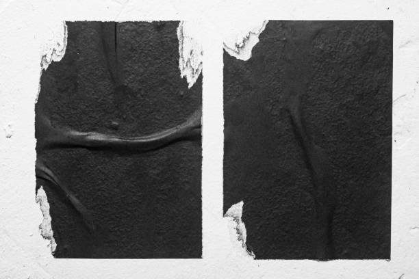 istock Two old black posters on a white wall close-up. 2198208358