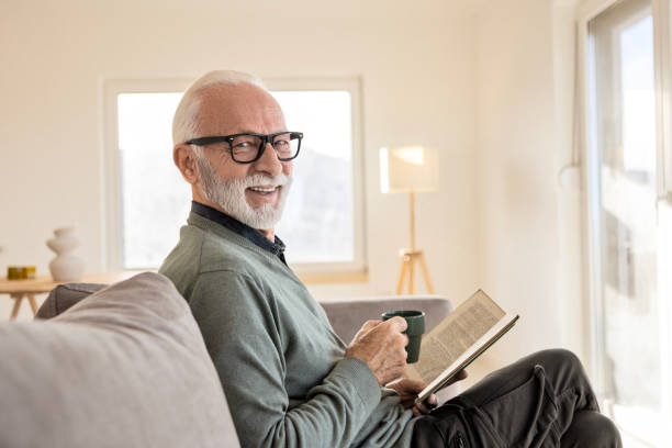 istock Smiling Man Relaxing with Coffee and His Book Looking At Camera 2198213906