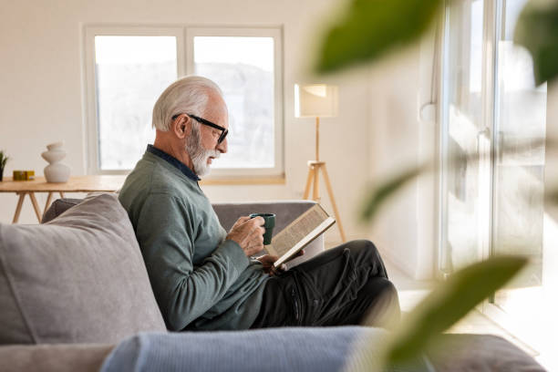 istock Smiling Man Relaxing with Coffee and His Book 2198213954