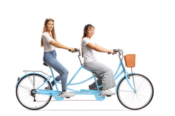 istock Young women riding a tandem bicycle 2198213996