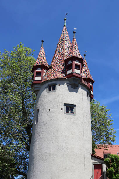 Low angle view of a historic clock tower in Regensburg, Bavaria, Germany. The stone structure stands against a clear blue sky, showcasing its architectural beauty.