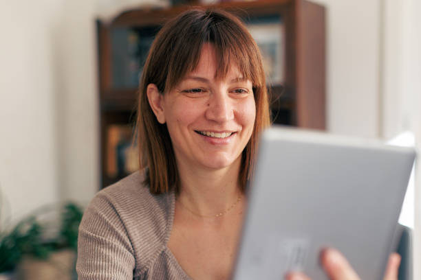 istock Smiling Woman 40-44 Using Tablet at Home 2198214212