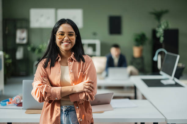 istock Confident woman standing in casual office setting. 2198214271
