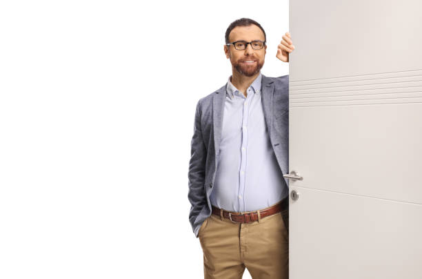 istock Man standing by a door and looking at camera 2198214386