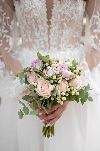 istock hands of the bride with a wedding bouquet 2198217947