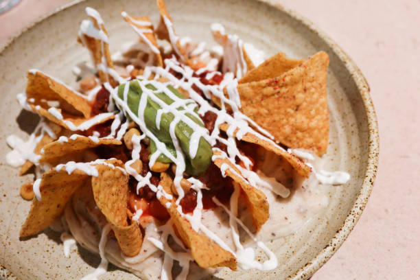 istock Mexican snacks nacho with sour cream and avocado sauce 2198220068