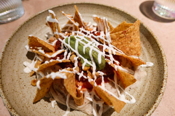 istock Mexican snacks nacho with sour cream and avocado sauce 2198220069