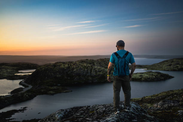 istock Explorer admiring scenic sunset view over rugged terrain and tranquil lake 2198220134