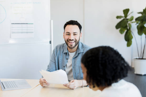 istock Happy Male Interviewee Discussing Ideas During Meeting 2198220588